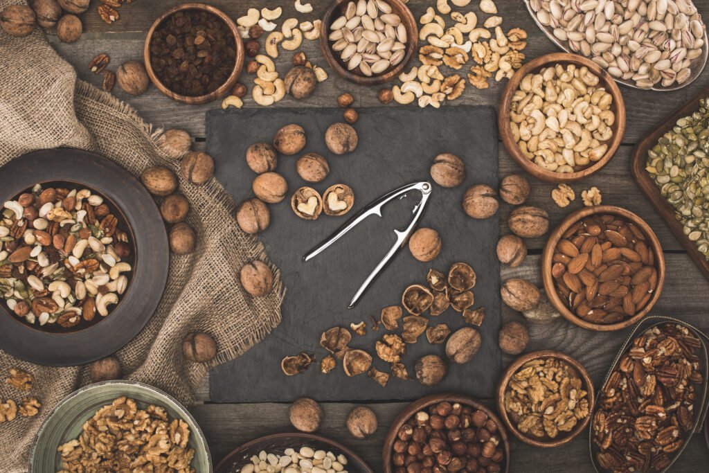 various nuts, sackcloth and nutcracker on wooden table top